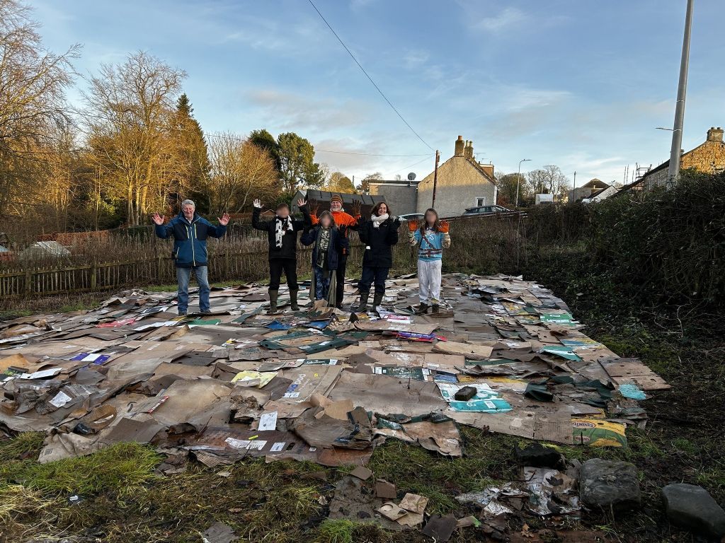 Volunteers laying cardboard to suppress persistent weeds